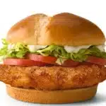 McDonald's Deluxe McCrispy sandwich with crispy chicken fillet, lettuce, tomatoes, cheese, and creamy mayo in a soft bun