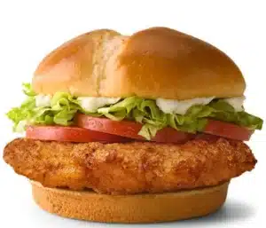 McDonald's Deluxe McCrispy sandwich with crispy chicken fillet, lettuce, tomatoes, cheese, and creamy mayo in a soft bun